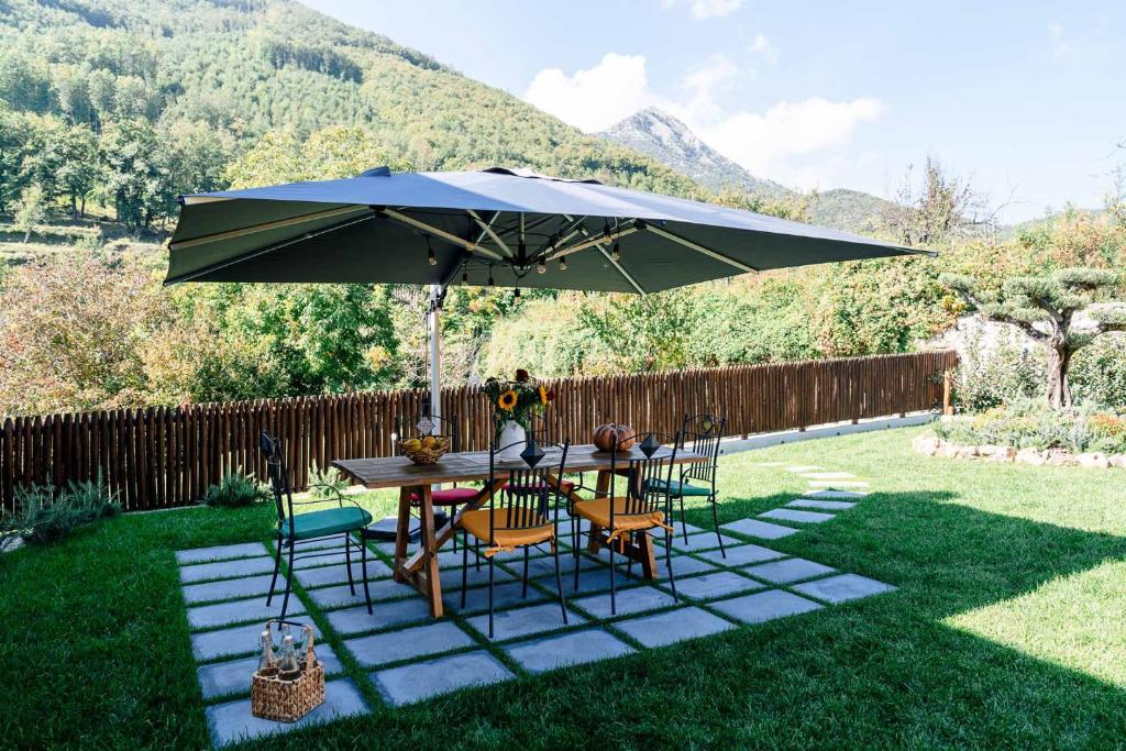 un tavolo e sedie sotto un ombrellone in un cortile di La Valle ad Agerola