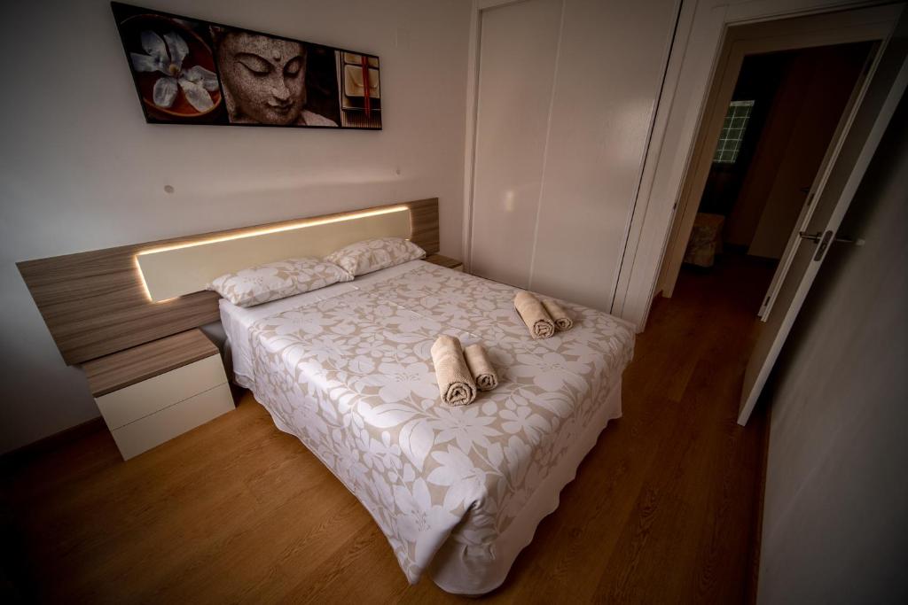 Un pequeño dormitorio con una cama con toallas. en Orillas del Castillo, en Alicante