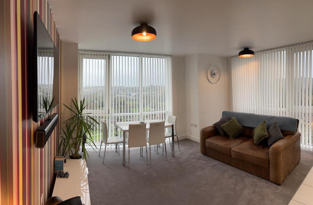 a living room with a couch and a table at K D Tower Lux Apartment in Hemel Hempstead