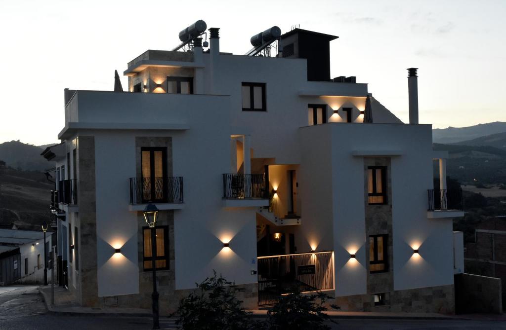 Un bâtiment blanc avec des lumières sur son côté dans l'établissement APTOS MILLÁN, à Ardales
