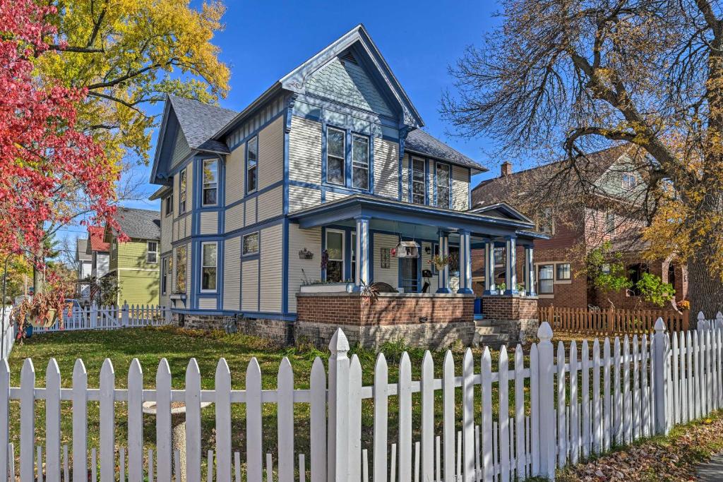 una casa azul y blanca con una valla blanca en Victorian Apartment Less Than 1 Mi to Wisconsin River, en Stevens Point