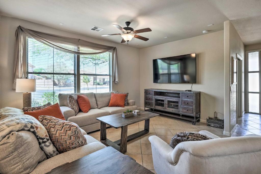 a living room with a couch and a tv at Goodyear Desert Oasis Walk to Community Pool in Goodyear