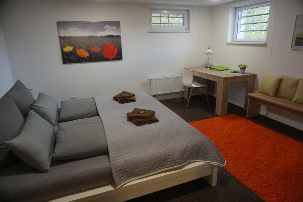 a bedroom with a bed and a desk and a table at Ferienwohnung Dorfzeit in Mörlenbach