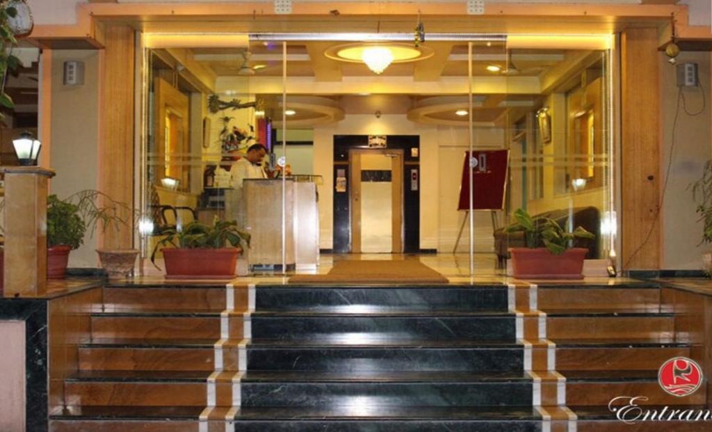 eine Lobby eines Gebäudes mit einer Treppe, die zum Eingang führt in der Unterkunft Ramakrishna International in Nanded-Waghala
