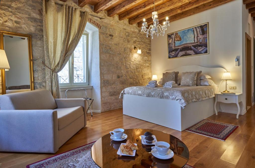 a bedroom with a bed and a couch and a table at Villa Split Heritage Hotel in Split