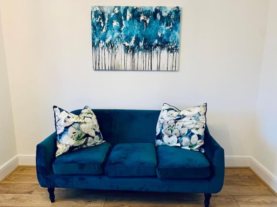 a blue couch with two pillows in a living room at Deluxe Detached 3 bedroom house near Sheffield in Rotherham