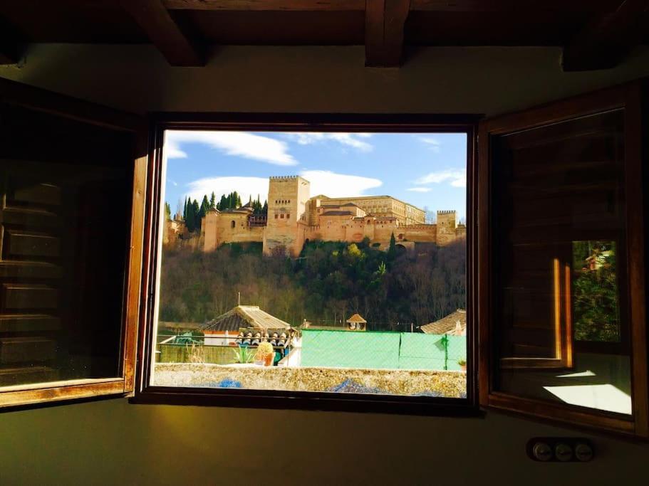 uma vista para um castelo a partir de uma janela em LA ROCHINA em Granada