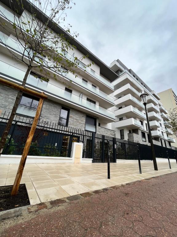 budynek z płotem przed nim w obiekcie Superbe appartement de 51m2 à 10mn de Paris w mieście Boulogne-Billancourt