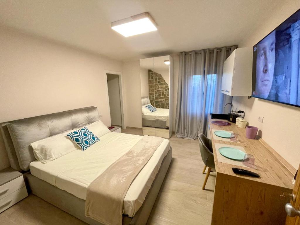 um quarto de hotel com uma cama e uma secretária e um quarto em CANALE SUITE panoramic view - private parking - Natural Park em Sinalunga