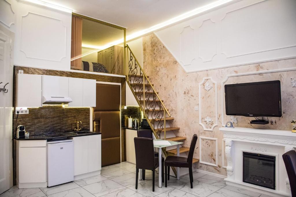 een keuken en eetkamer met een tafel en een tv bij Exclusive Apartmanok Szeged in Szeged