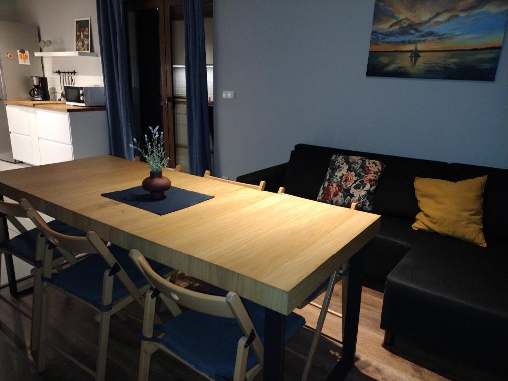 a living room with a wooden table and a couch at Dom Mazurska Apartamenty in Rydzewo