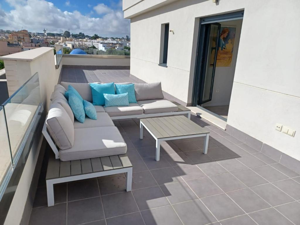 patio z kanapą i stołem na dachu w obiekcie Atico Costa Doñana w mieście Sanlúcar de Barrameda