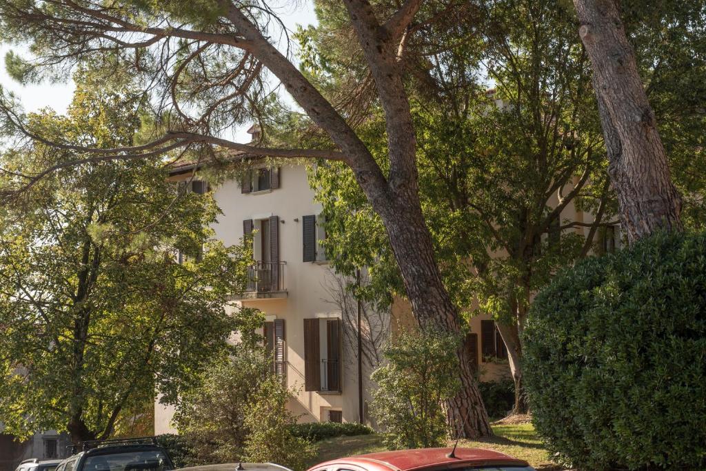 un edificio blanco con árboles delante de él en Rooms Relais Art Borgocastello3 en Gorizia