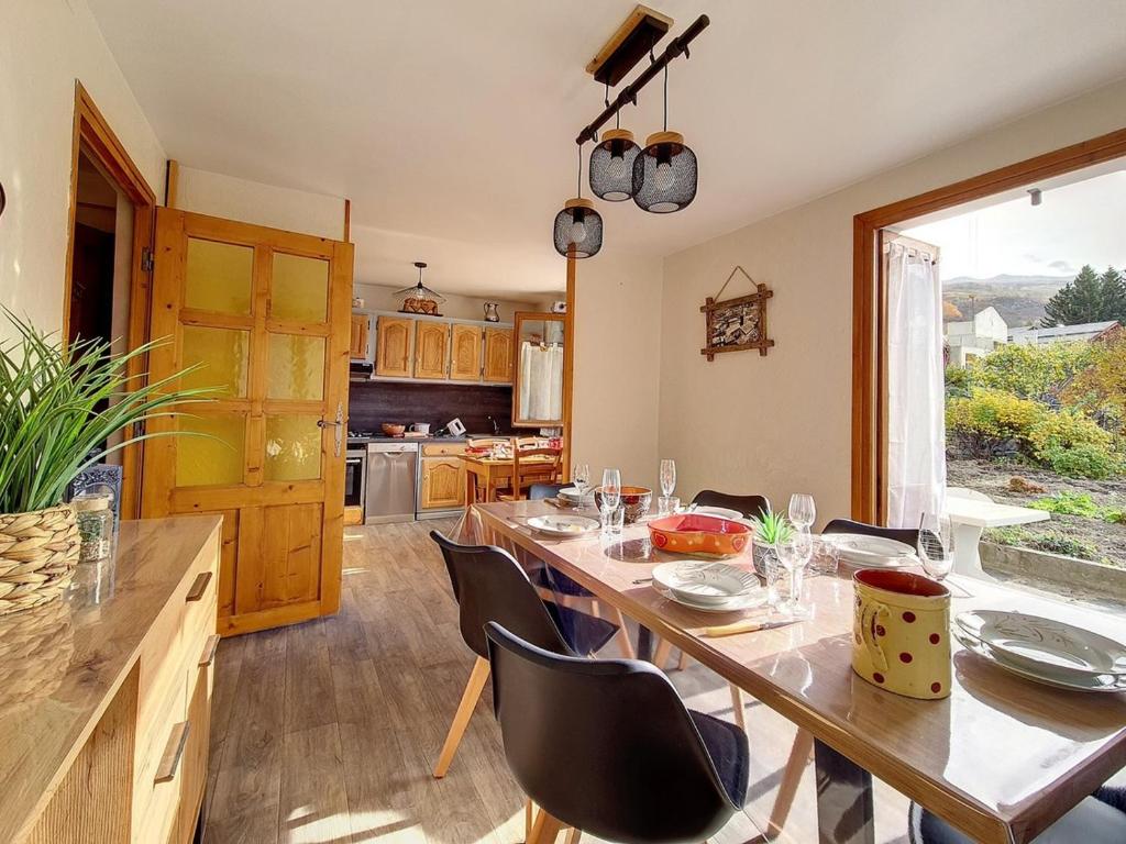 a dining room with a table and chairs and a kitchen at Chalet familial à St Marcel avec terrasse, 6 pers, 3 chambres - FR-1-344-1051 in Saint-Marcel