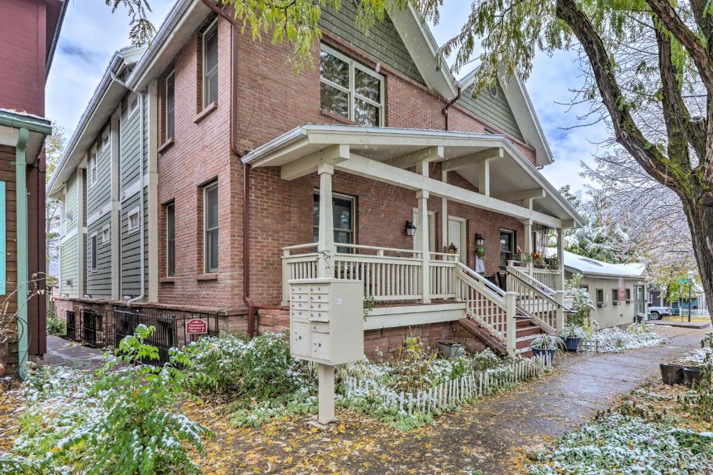 a red brick house with a porch and a balcony at Cozy Central Glenwood Springs Condo with 2 Decks! in Glenwood Springs