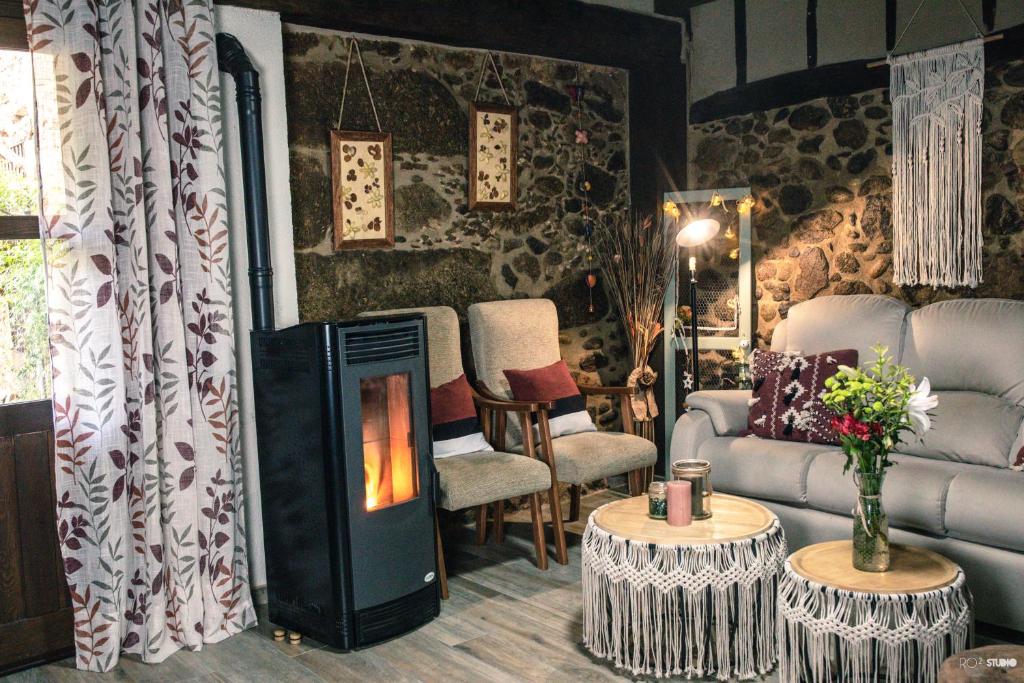 sala de estar con chimenea y sofá en Picaza del Jerte, en Cabezuela del Valle