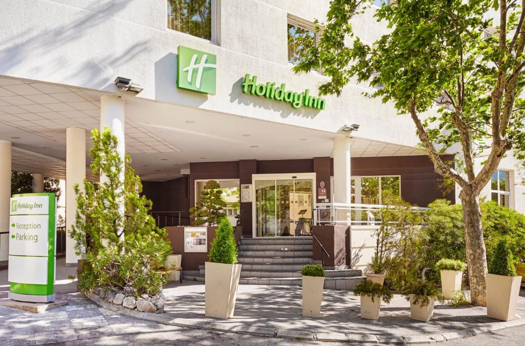 un magasin devant un bâtiment avec des plantes devant dans l'établissement Holiday Inn Toulon City Centre, an IHG Hotel, à Toulon