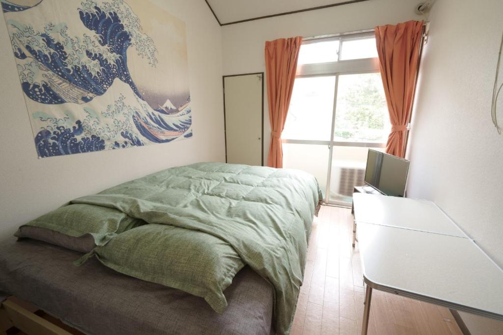 福岡的住宿－Garden House Ozasa - Vacation STAY 9178，卧室配有一张床,墙上挂有绘画作品