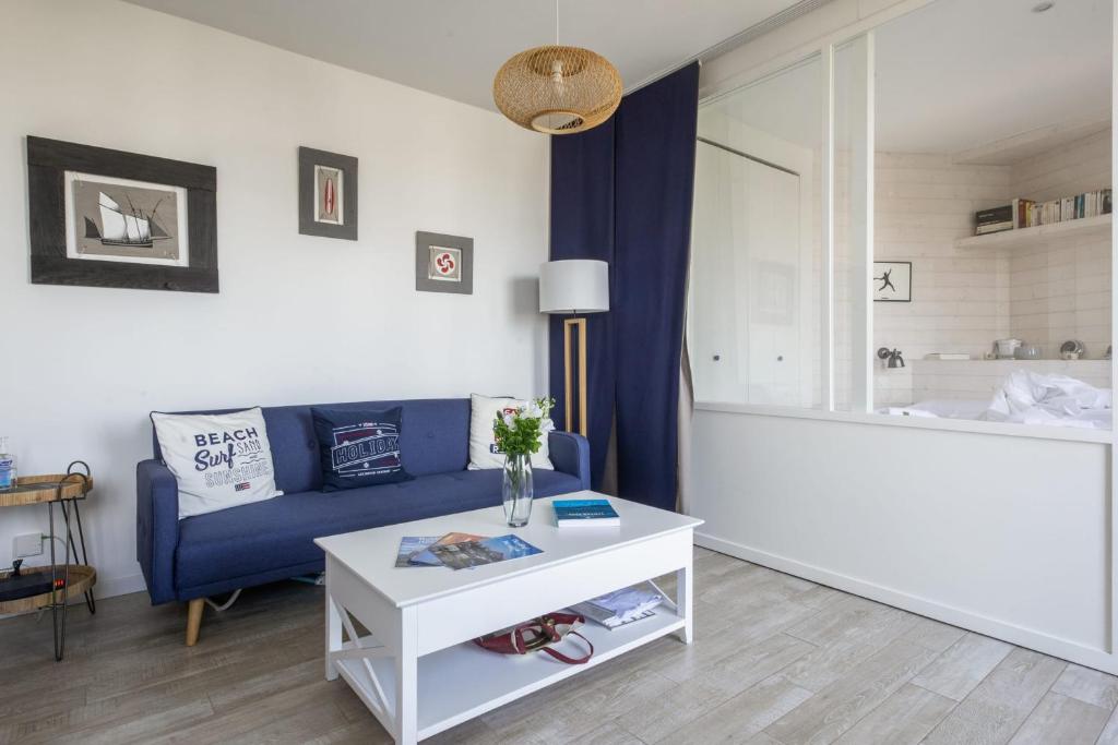a living room with a blue couch and a white table at Studio Limpo - Welkeys in Hendaye
