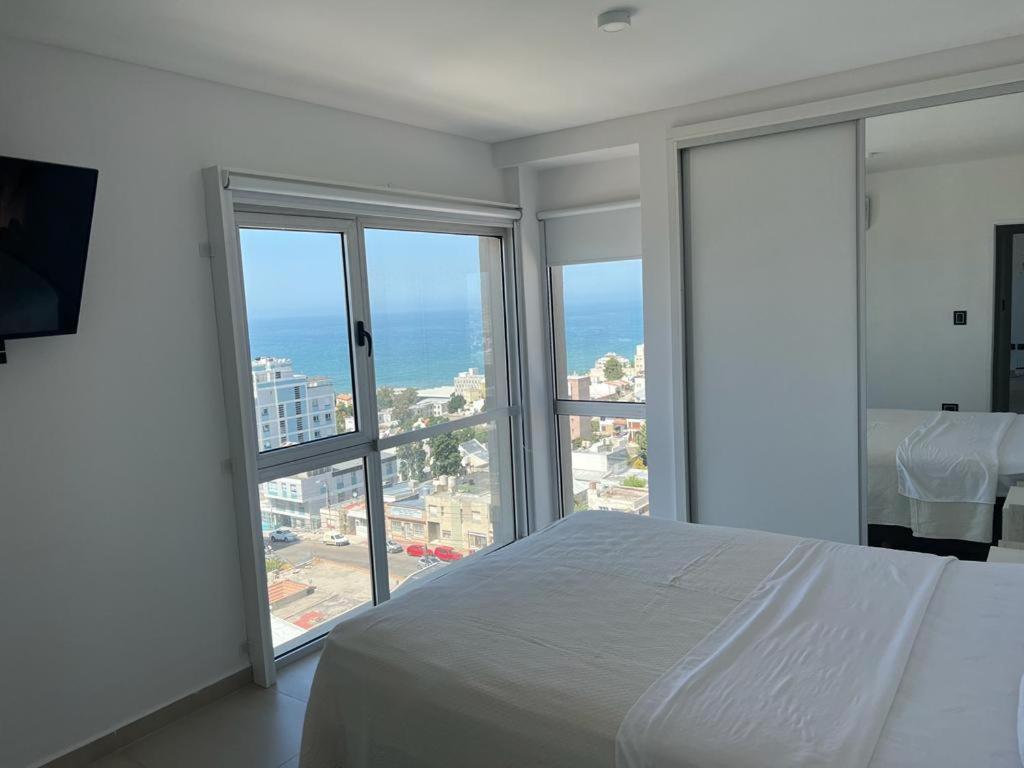 een slaapkamer met een bed en uitzicht op de oceaan bij Moderno Depto con Vista al Mar in Comodoro Rivadavia