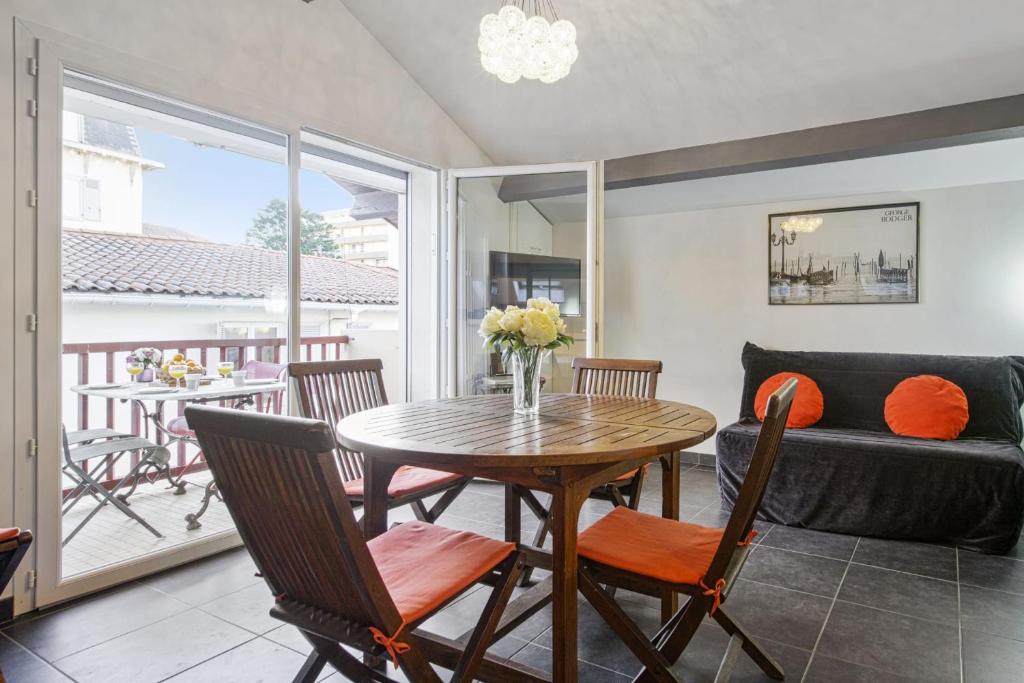 a living room with a table and chairs and a couch at Large studio with balcony at the heart of Biarritz - Welkeys in Biarritz