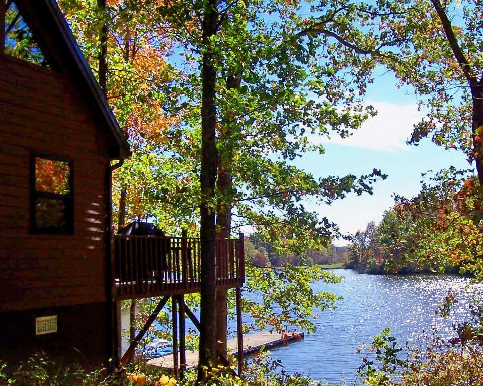 uma vista para um rio com uma casa e árvores em Hocking Hills Lake Gem with Hot Tub, Dock, 100 Acres em Hamden