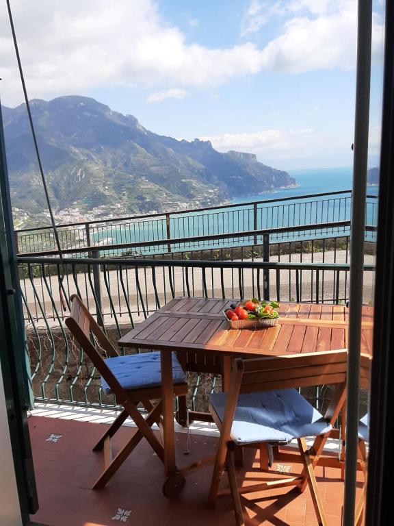 Dan Ravello في رافيلو: طاولة وكراسي على شرفة مطلة على المحيط