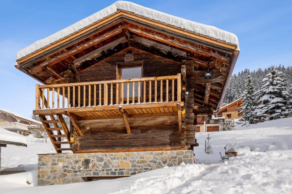 una baita di tronchi con balcone nella neve di L'Échappée Belle - Welkeys a La Clusaz