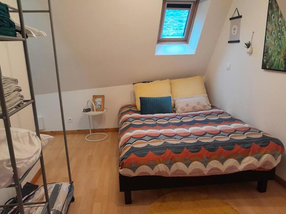 ein kleines Schlafzimmer mit einem Bett in einem Zimmer in der Unterkunft Duplex charmant au coeur de Levroux in Levroux