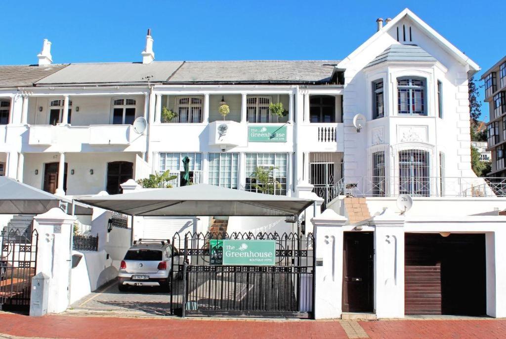 un edificio blanco con un paraguas delante en The Greenhouse Guesthouse, en Ciudad del Cabo