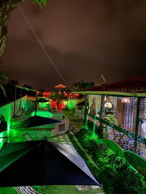 a night view of a house with green lights at HTL PERSONALIZADA BUZIOS in Búzios