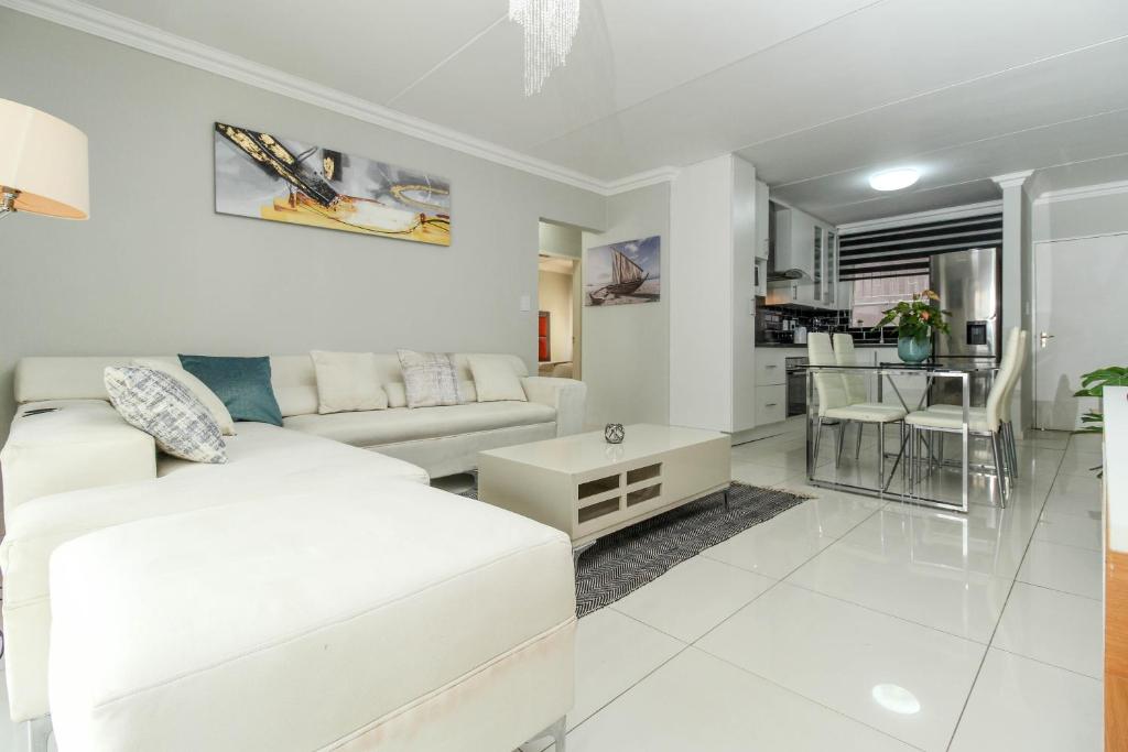 a white living room with a couch and a table at Gorgeous Diamond in Midrand