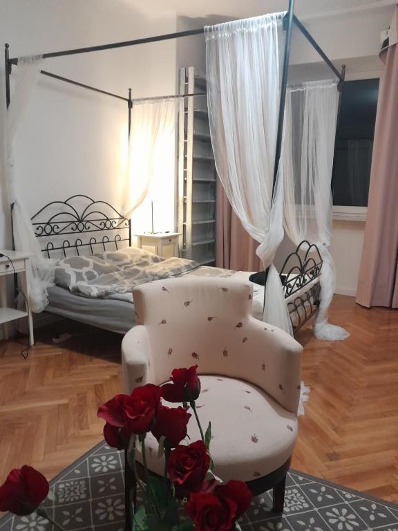 a bedroom with a bed and a chair and roses at WARSZAWA, CENTRUM, Wiejska 15, KAMIENICA in Warsaw
