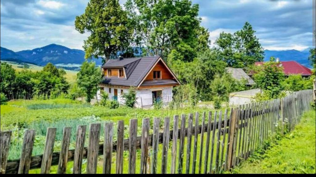 una casa con una valla de madera frente a un campo en Chata pod lipou Bobrovník, en Bobrovník