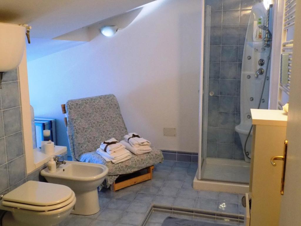 ein Badezimmer mit einer Dusche, einem WC und einem Stuhl in der Unterkunft Il Ciliegio del Pellegrino in Gubbio