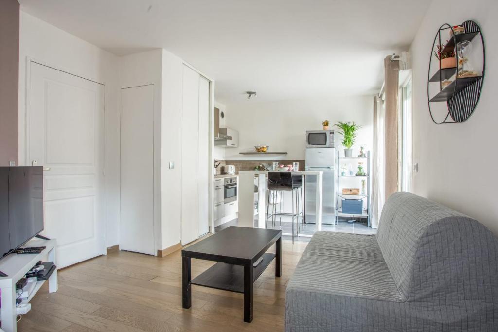 un salon avec un canapé et une table dans l'établissement Studio Difesa - Welkeys, à Courbevoie