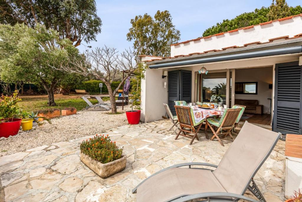 a patio with a table and chairs in a yard at Villa des Rives - Welkeys in Grimaud