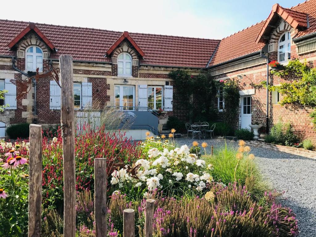 ein Haus mit einem Blumengarten davor in der Unterkunft La Ferme du P'tit Colibri in Gury