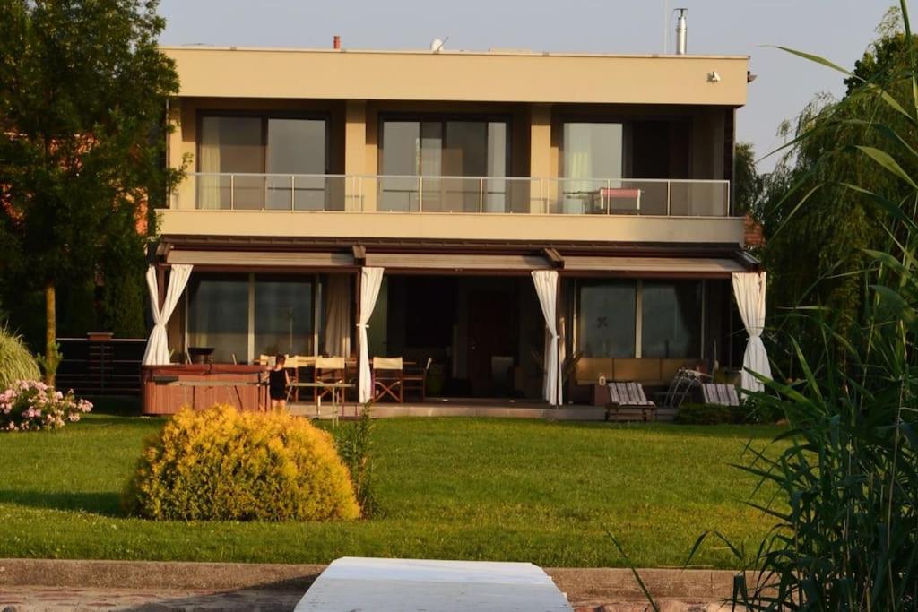 Luxury Lakefront Villa with Private Pier & Jacuzzi في بالاتونوشود: منزل كبير مع شرفة على الحديقة