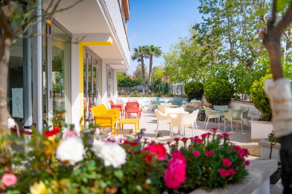 a patio with chairs and tables and flowers at Hotel Royal in Giulianova
