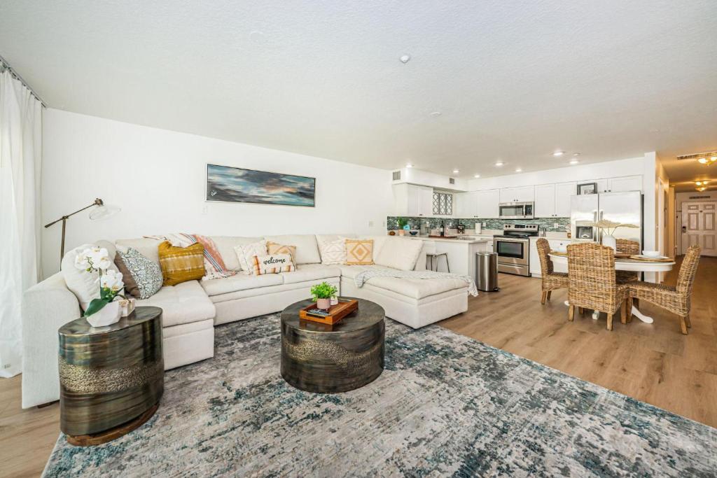 a living room with a white couch and a kitchen at White Dunes Condo in Clearwater Beach