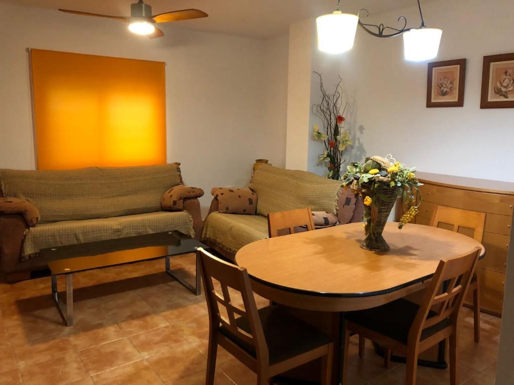 een woonkamer met een tafel en een bank bij Apartamento rural cerca del centro in Caudete