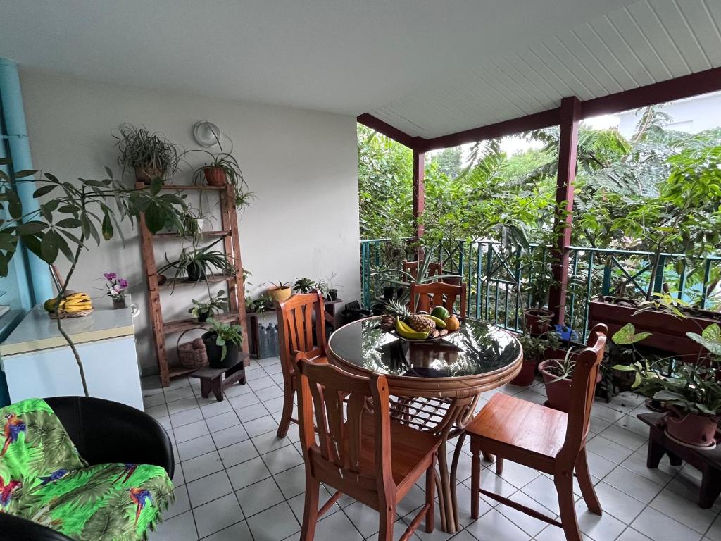 a room with a table and chairs and a balcony at Chambre Chez l'habitant à 5mn de l'aéroport in Les Abymes