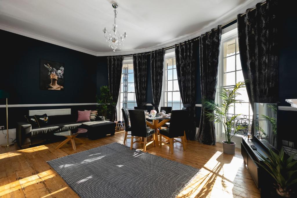 a living room with a table and chairs and a couch at Marine Parade Sea View 2-Bedroom Apartment in Brighton & Hove