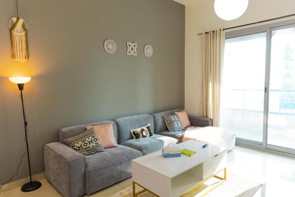 a living room with a couch and a table at Himalaya Homes Lovely 1 Bedroom Apartment in Dubai