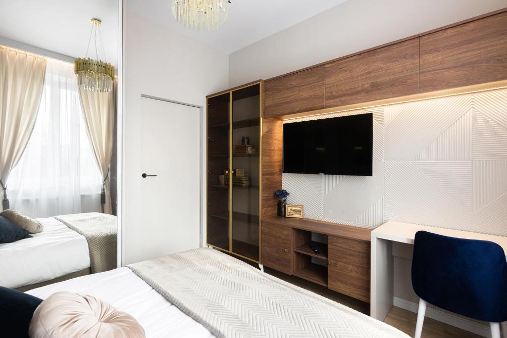 1 dormitorio con 1 cama, escritorio y TV en Blue Residence Orawska 5 en Cracovia