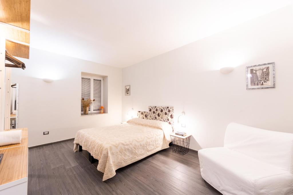 una camera bianca con un letto e un divano di Bien-Bì a Napoli