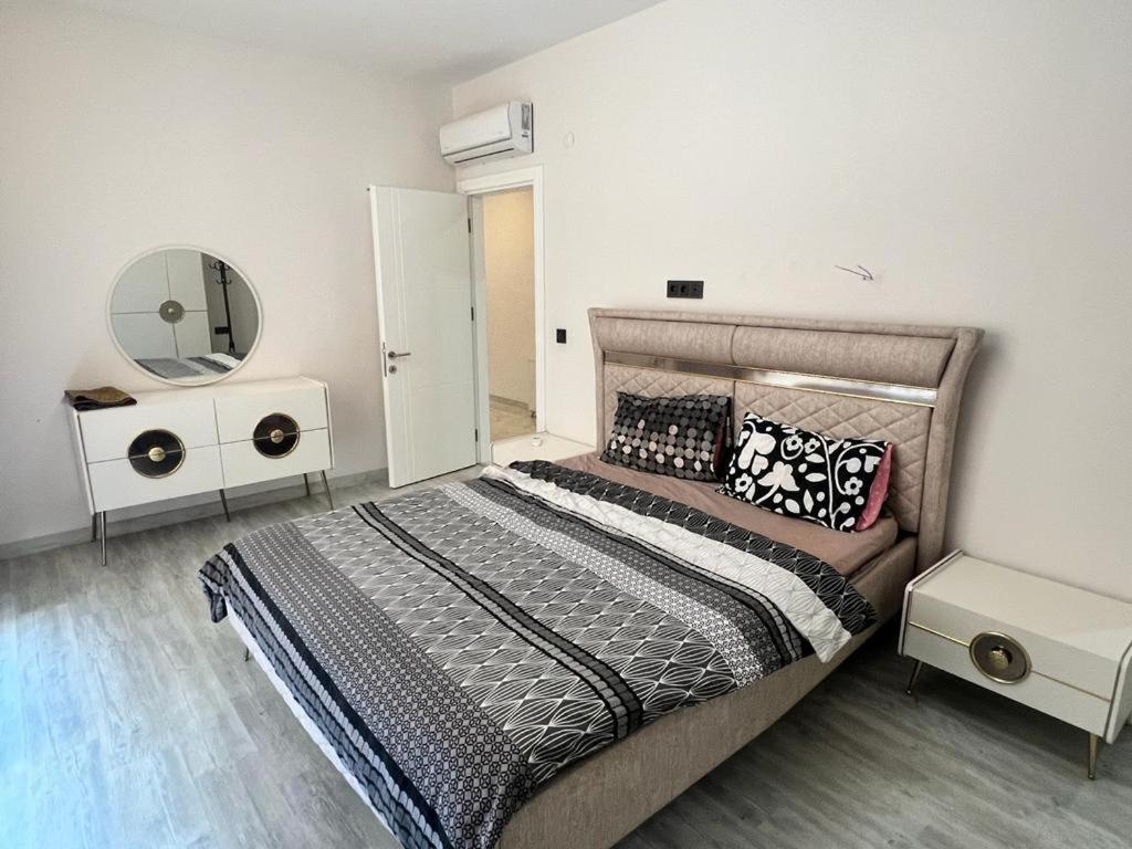 1 dormitorio con 1 cama grande y espejo en Aydemir park Mahmutlar 2, en Alanya