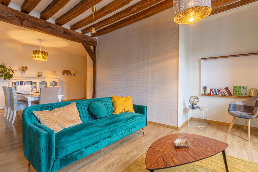 a living room with a green couch and a table at L' appartement de la Paix in Romorantin