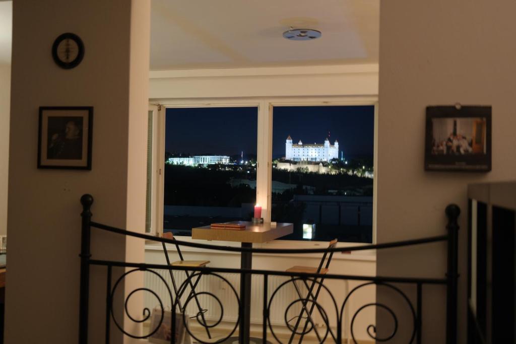 a room with a table and a window with a candle at Studio with a view of the center of Bratislava in Bratislava